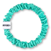 Türkiser Seiden Scrunchie "Kunst, stark zu bleiben" von BRUNCHIES® x Nike Schröder aus 100 % Maulbeerseide.